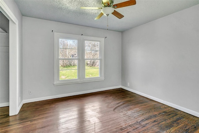 unfurnished room featuring a textured ceiling, ceiling fan, wood finished floors, and baseboards