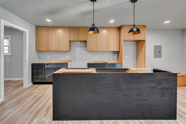 kitchen with recessed lighting, a kitchen island, light wood-type flooring, electric panel, and decorative light fixtures