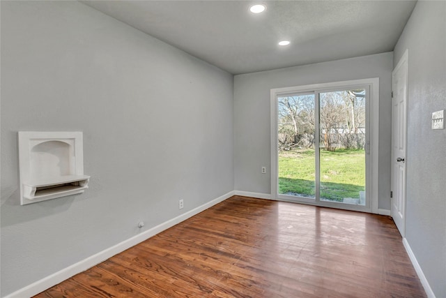 empty room with recessed lighting, baseboards, and wood finished floors