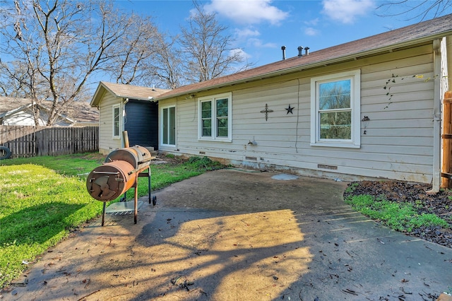 rear view of house featuring a patio, a yard, crawl space, and fence