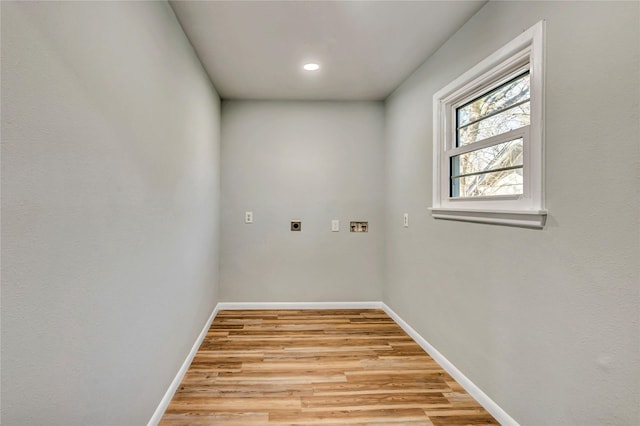 laundry area featuring laundry area, light wood-style flooring, baseboards, and electric dryer hookup