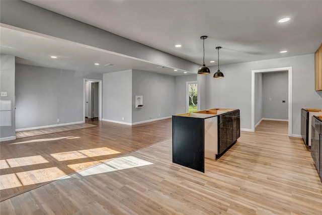 kitchen featuring light wood-type flooring, a center island, baseboards, and recessed lighting