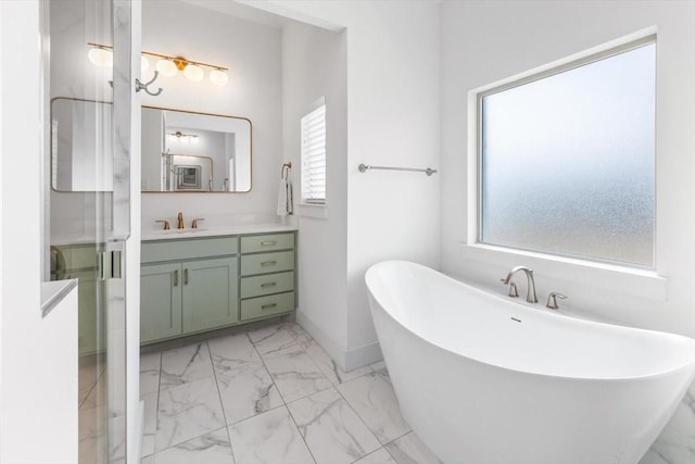 bathroom featuring marble finish floor, a freestanding tub, vanity, and a shower stall