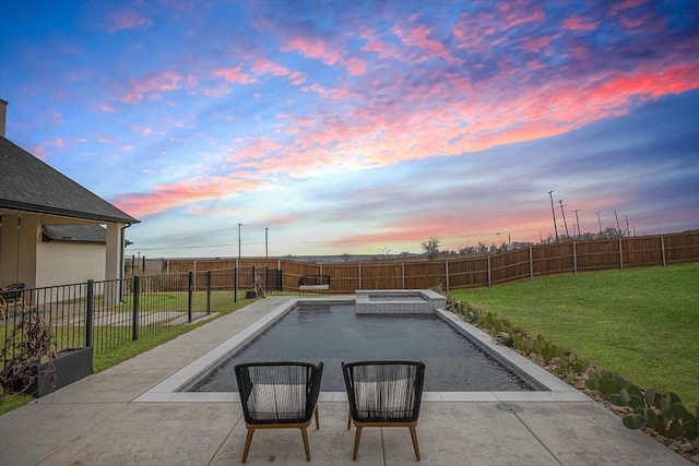 pool at dusk featuring a patio area, a fenced backyard, a pool with connected hot tub, and a lawn