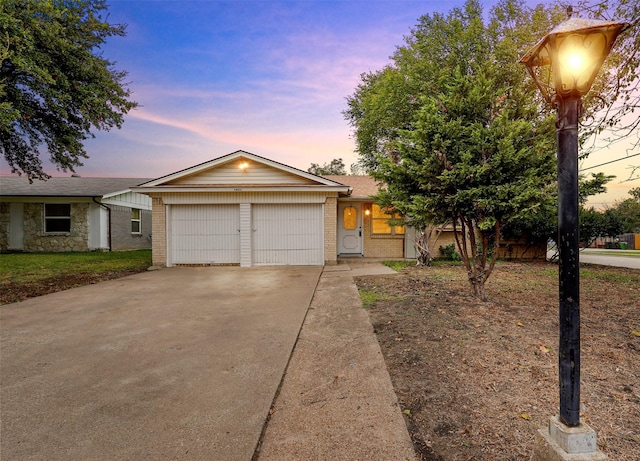 single story home featuring brick siding, concrete driveway, and an attached garage