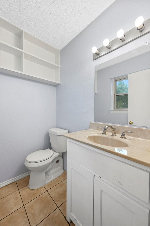 half bathroom featuring vanity, baseboards, tile patterned flooring, a textured ceiling, and toilet