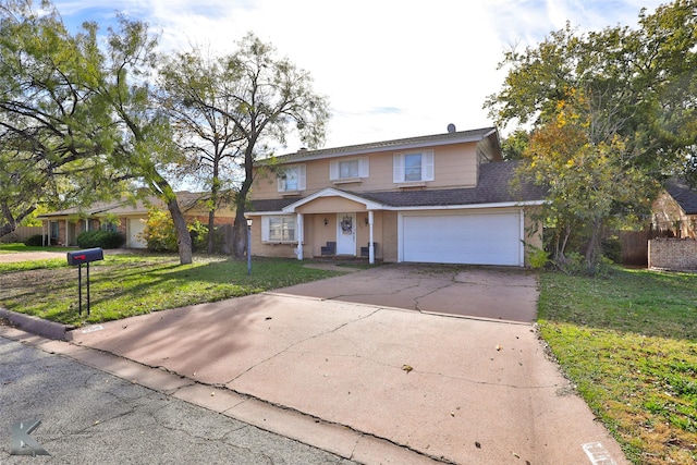 traditional-style house with a garage, fence, concrete driveway, roof with shingles, and a front lawn