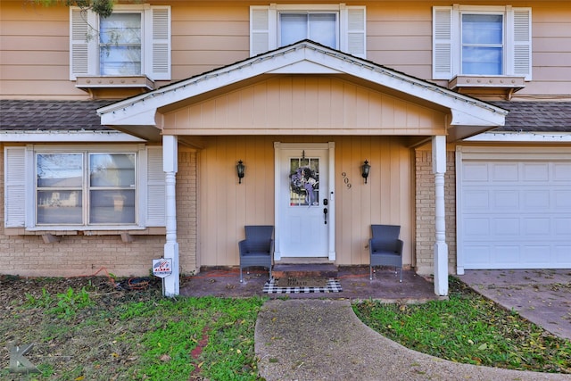 doorway to property with a garage, roof with shingles, and brick siding