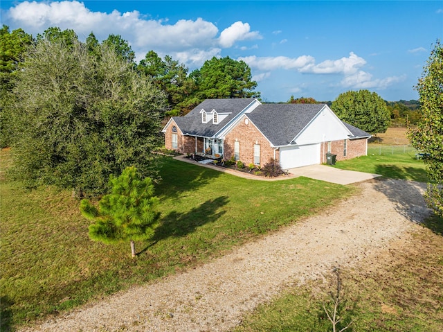 view of front of home with a garage, brick siding, driveway, and a front lawn