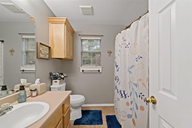 bathroom with visible vents, toilet, vanity, a textured ceiling, and tile patterned flooring