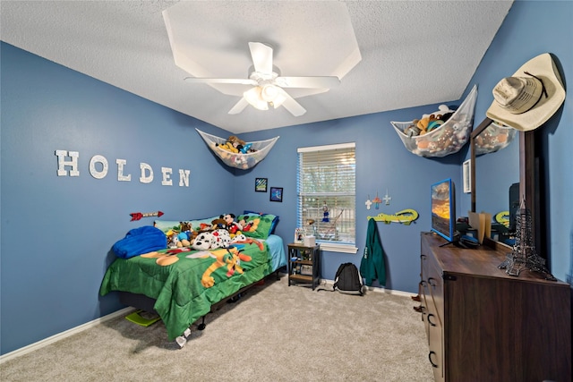 carpeted bedroom featuring ceiling fan, baseboards, and a textured ceiling