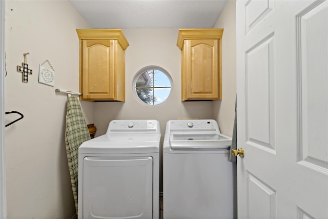 clothes washing area featuring a textured ceiling, independent washer and dryer, and cabinet space