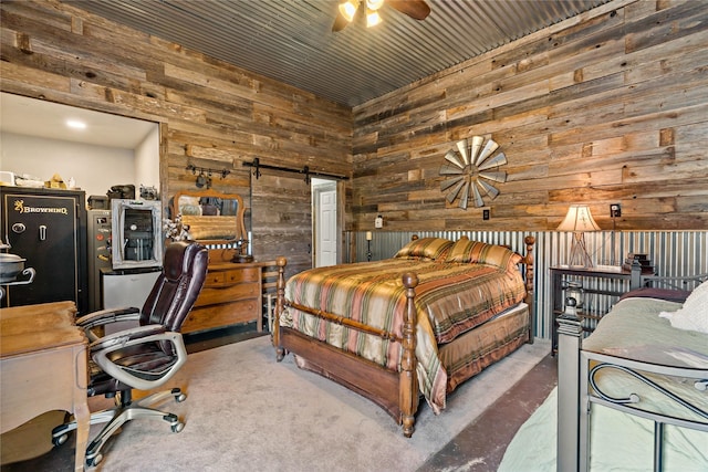 bedroom featuring a barn door and wooden walls