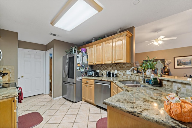 kitchen featuring light tile patterned floors, tasteful backsplash, visible vents, appliances with stainless steel finishes, and a sink