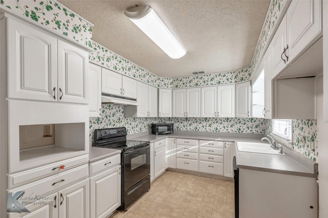 kitchen featuring white cabinetry, a sink, a textured ceiling, under cabinet range hood, and black appliances