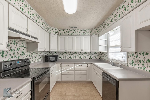 kitchen with wallpapered walls, visible vents, under cabinet range hood, black appliances, and a sink