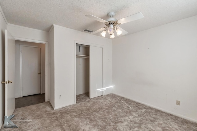 unfurnished bedroom with carpet floors, a closet, and a textured ceiling