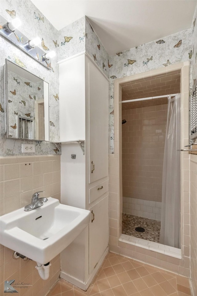 bathroom featuring a sink, tile walls, decorative backsplash, tile patterned floors, and a stall shower