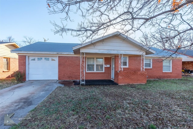 view of front of house featuring a front yard, concrete driveway, brick siding, and an attached garage