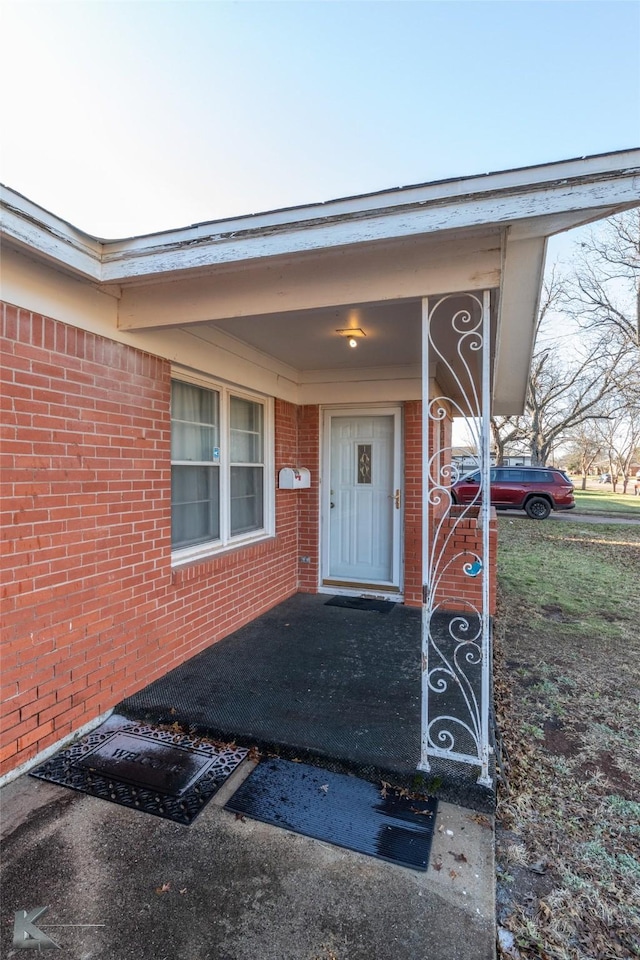 entrance to property featuring brick siding