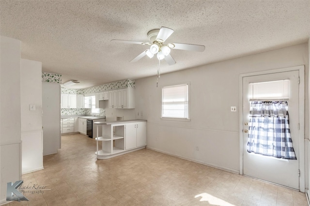 kitchen featuring light floors, a wealth of natural light, and white cabinets