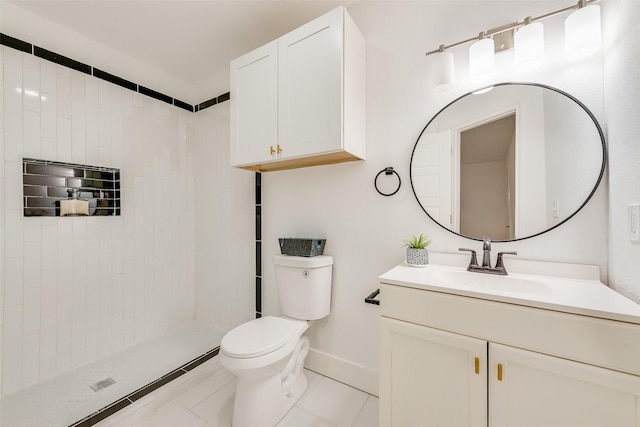 bathroom with toilet, baseboards, tiled shower, and vanity