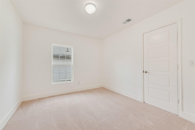 unfurnished room featuring carpet, visible vents, and baseboards