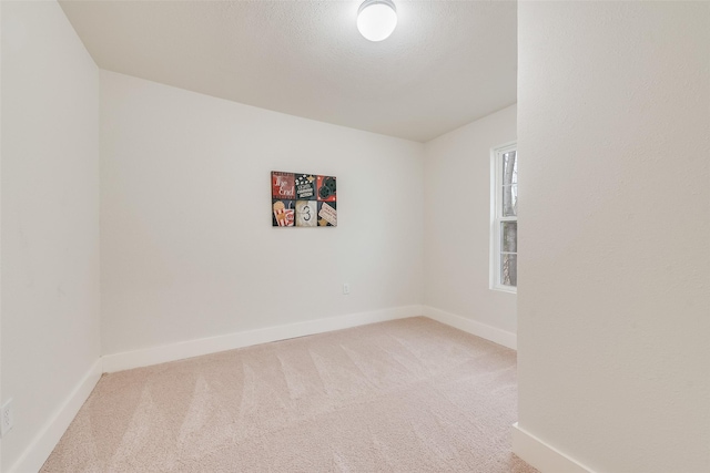 unfurnished room featuring carpet and baseboards