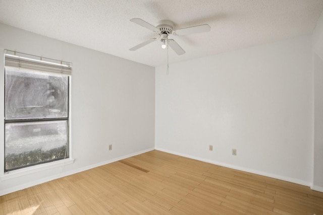 unfurnished room featuring ceiling fan, a textured ceiling, baseboards, and wood finished floors