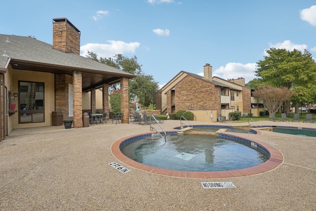 pool featuring a patio area and a community hot tub