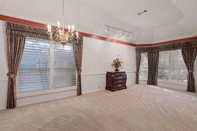 interior space with rail lighting, an inviting chandelier, carpet flooring, and visible vents