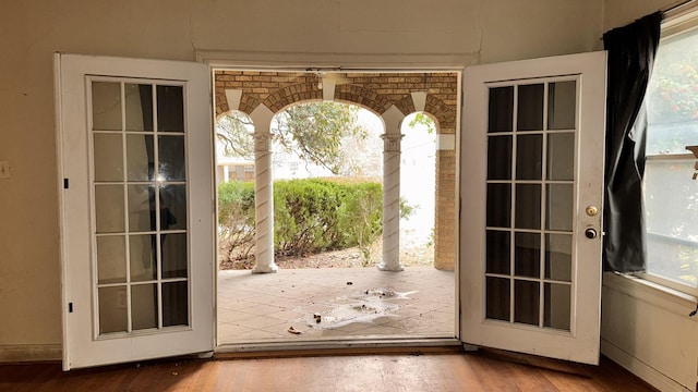 doorway to outside with a healthy amount of sunlight, baseboards, and wood finished floors