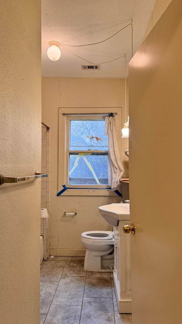 bathroom with visible vents, vanity, tile patterned flooring, and toilet