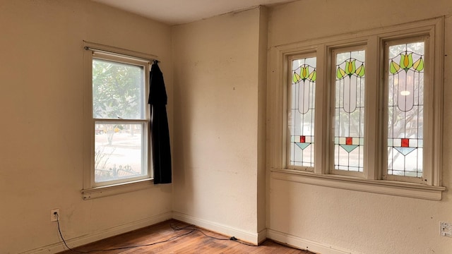 spare room featuring light wood-style floors and baseboards