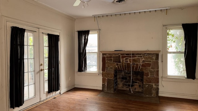 unfurnished living room with a fireplace, wood finished floors, and a healthy amount of sunlight