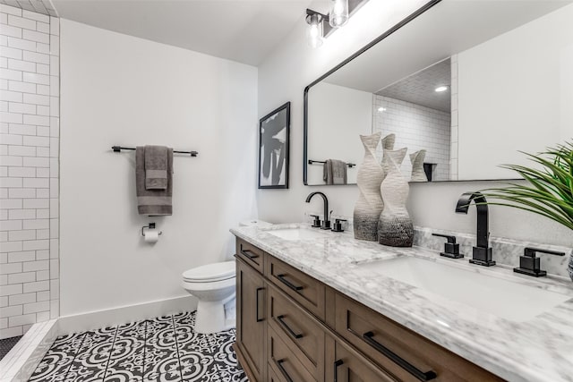 full bath featuring double vanity, tile patterned flooring, a sink, and toilet