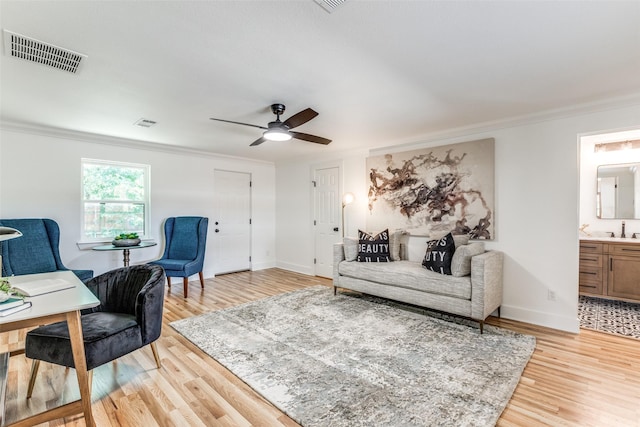 interior space with light wood-type flooring, baseboards, visible vents, and crown molding