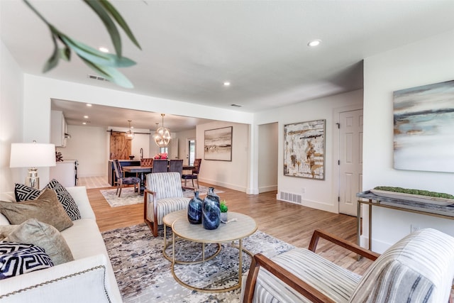 living area with light wood-style floors, baseboards, visible vents, and recessed lighting