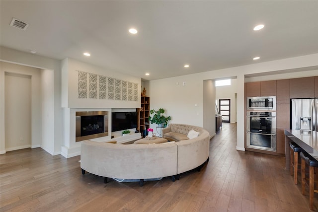 3743 Pistol Creek Dr, Frisco, TX 75034 - living room with dark wood-style floors, a glass covered fireplace, recessed lighting, and baseboards