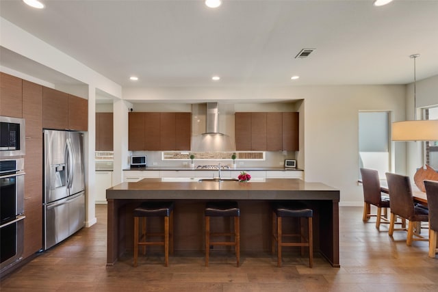 3743 Pistol Creek Dr, Frisco, TX 75034 - kitchen with stainless steel appliances, modern cabinets, a breakfast bar area, recessed lighting, and brown cabinetry