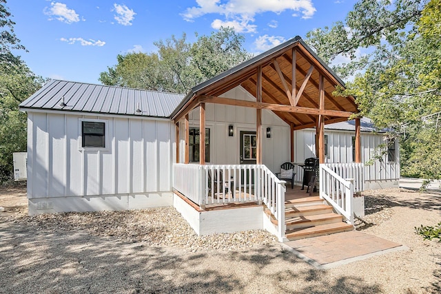 view of front of house with a porch, metal roof, and board and batten siding