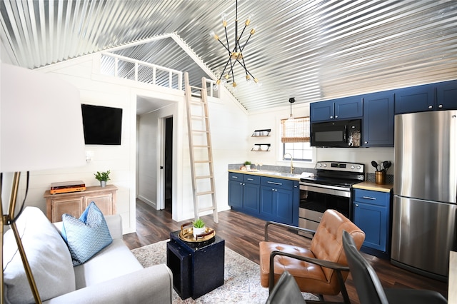 kitchen featuring lofted ceiling, stainless steel appliances, blue cabinetry, dark wood-style floors, and an inviting chandelier