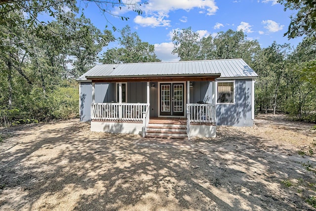 view of front of home with covered porch, metal roof, and board and batten siding