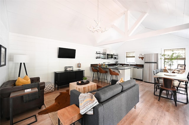 living room featuring light wood-type flooring, vaulted ceiling with beams, and an inviting chandelier