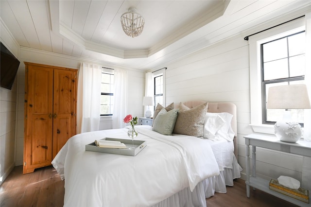 bedroom featuring wooden ceiling, ornamental molding, a raised ceiling, and wood finished floors