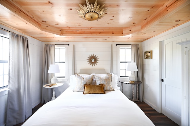 bedroom with a tray ceiling, wood ceiling, dark wood finished floors, and wood walls