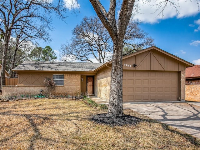 ranch-style home with a garage, driveway, brick siding, and a front yard