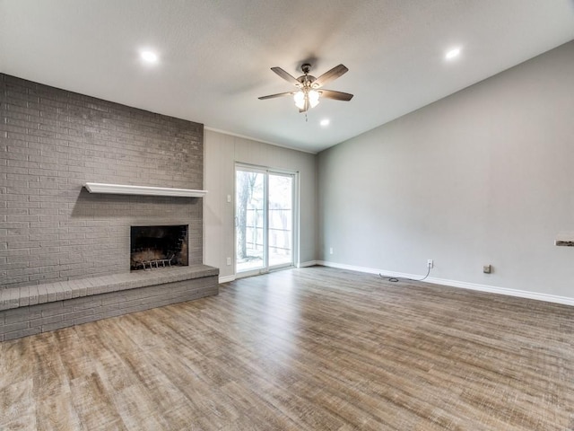 unfurnished living room featuring recessed lighting, a fireplace, wood finished floors, a ceiling fan, and baseboards