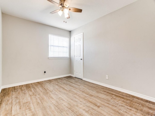 spare room with baseboards, a ceiling fan, and wood finished floors