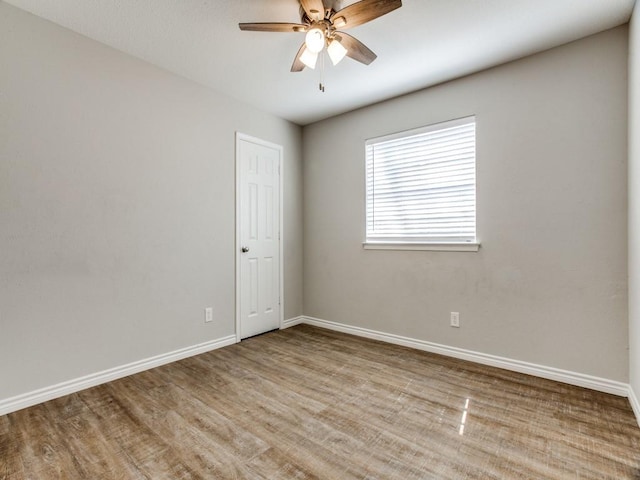 unfurnished room with ceiling fan, wood finished floors, and baseboards